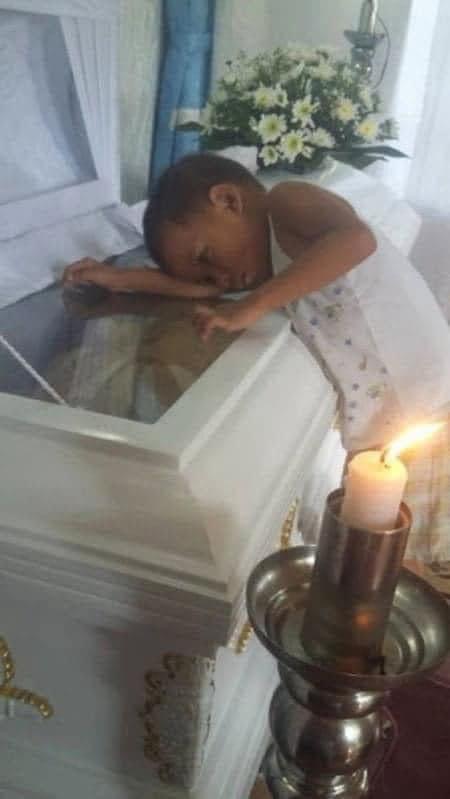 Child silently approaches mother’s coffin, presses head against it during service